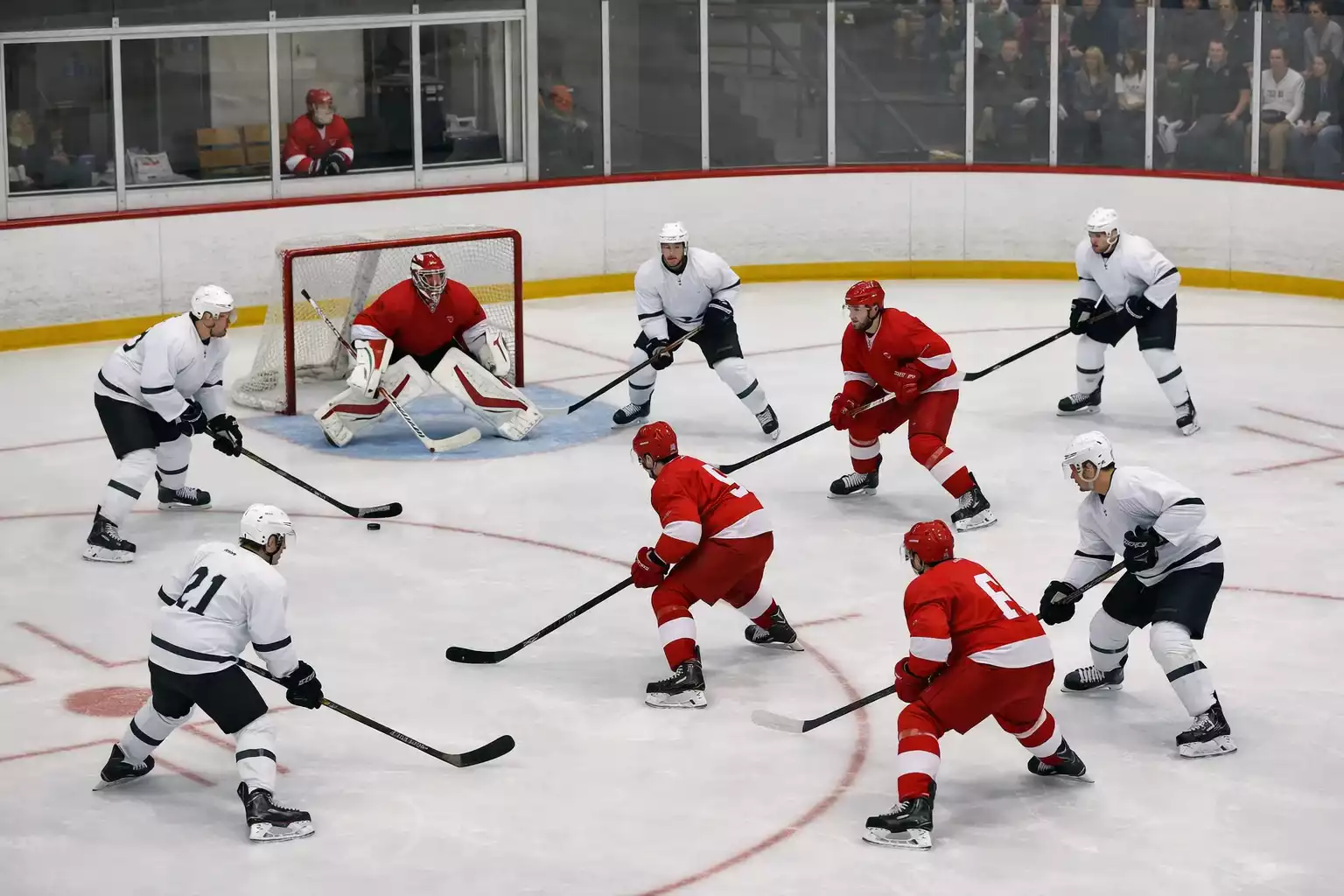 Joueurs de hockey dans la zone offensive devant le but